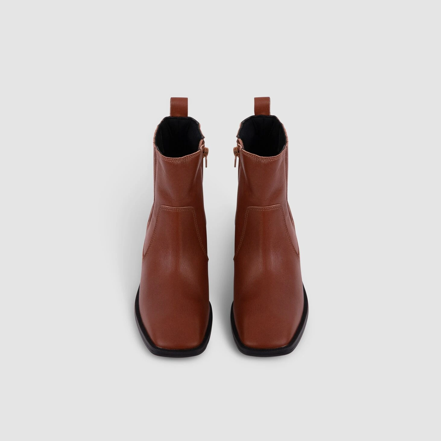 Bottines Naples en cuir cognac de face, mettant en valeur la fermeture éclair et le design épuré de Poema Paris.